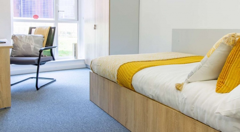 Cozy student room with bed, chair, and window at The Croft, Derby