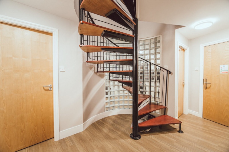 Spiral staircase with wooden steps in a hallway with wooden doors Mezzino Manchester