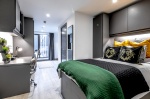 studio apartment featuring a comfortable bed, study area, kitchenette, and en-suite bathroom.