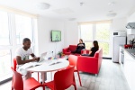 Students in the communal shared area with TV, sofas and dining table at  Abbey House, Coventry