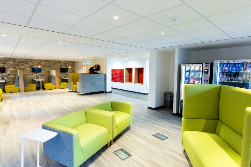 Spacious and modern common area with green sofas at the student accommodation Abbey House Coventry