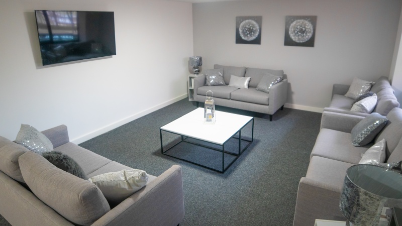 Comfortable communal lounge with seating and a large TV at Unity Square, Liverpool