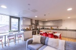 Spacious common room with contemporary furnishings, large windows, and a vibrant atmosphere