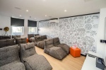 Cinema room with bean bag chairs and large TV in Crosstrend House