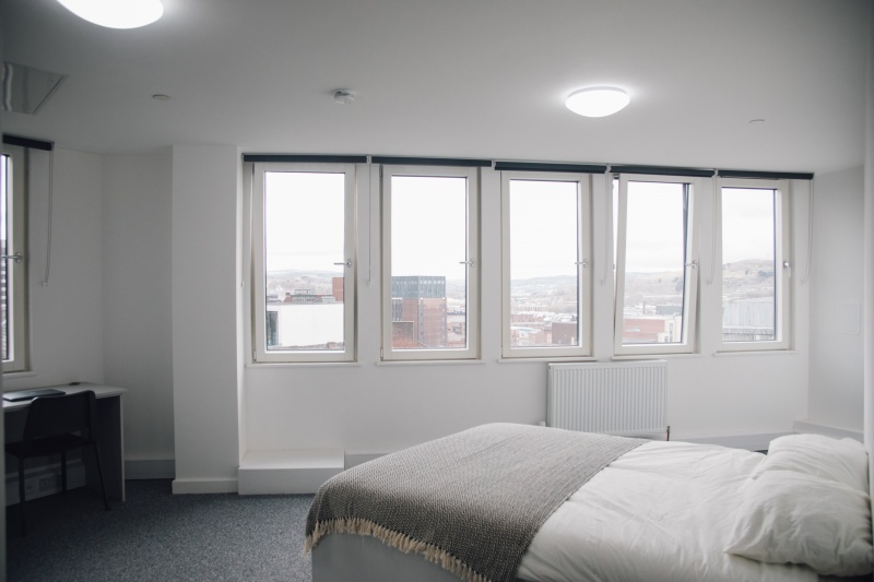 Bright room studio with windows, bed and study desk at The Paper Works in Sheffield