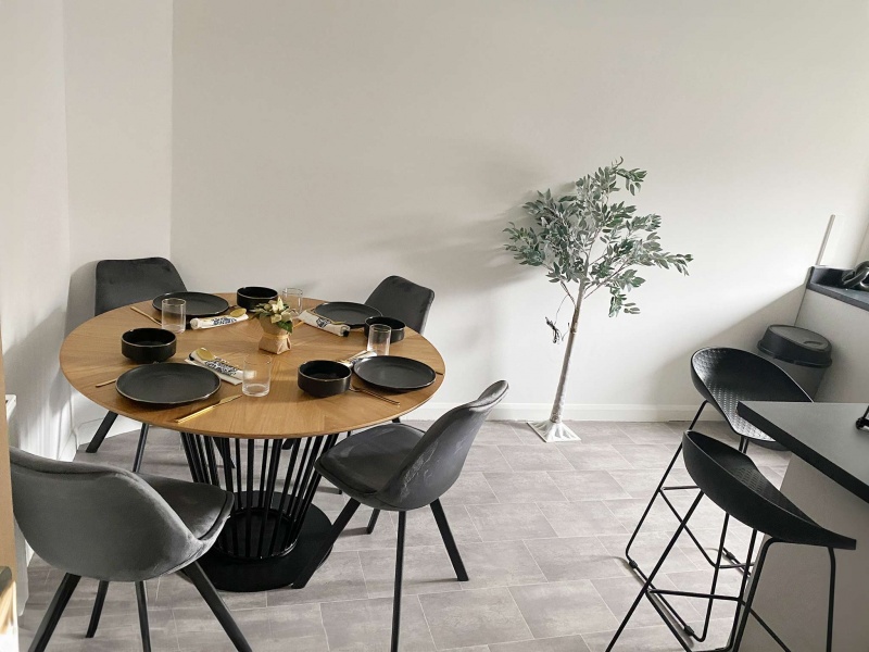 Modern dining area with table, chairs & plant. Bright space for meals Park Village 