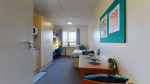 Bright bedroom with a study desk and window at Creek Court accommodation London