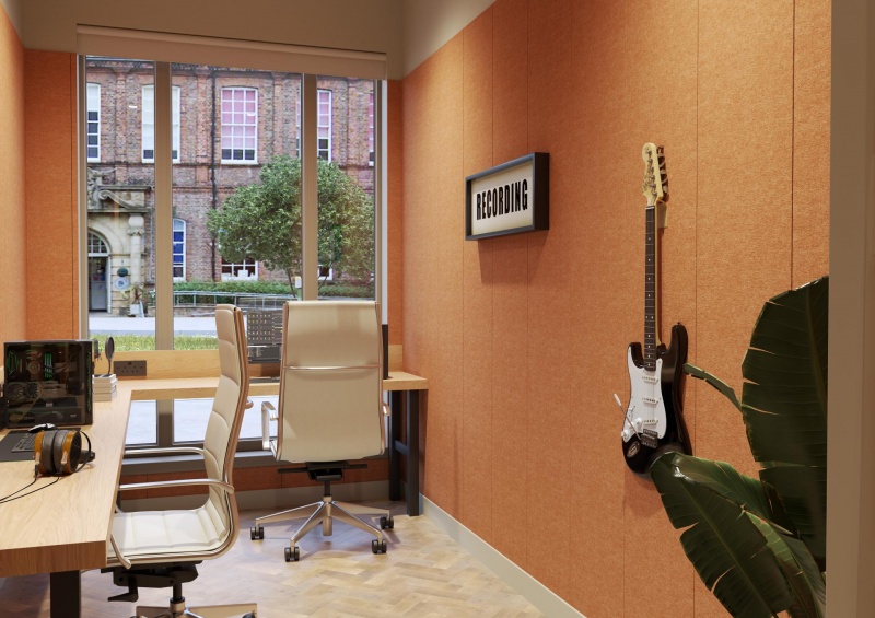 Recording studio space in Fusion York with desk, gaming setup, and guitar