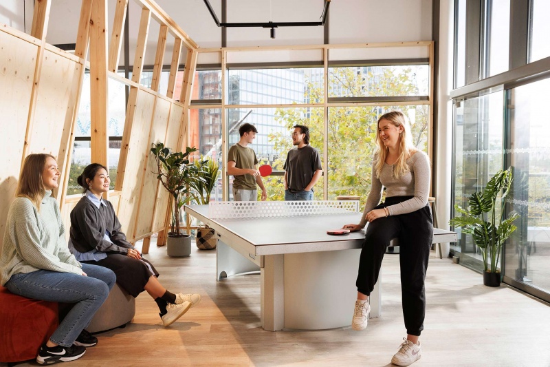 Social area at Stratford One student accommodation, London, with students lounging on sofas