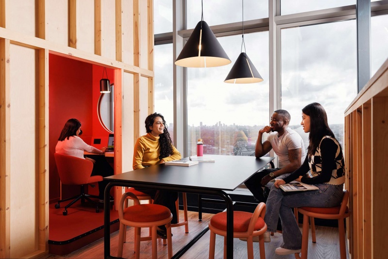 A well-lit study area at Stratford One student accommodation in London, with students sitting