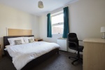 double comfortable bed with a study desk and window at Bedford Street South, Liverpool