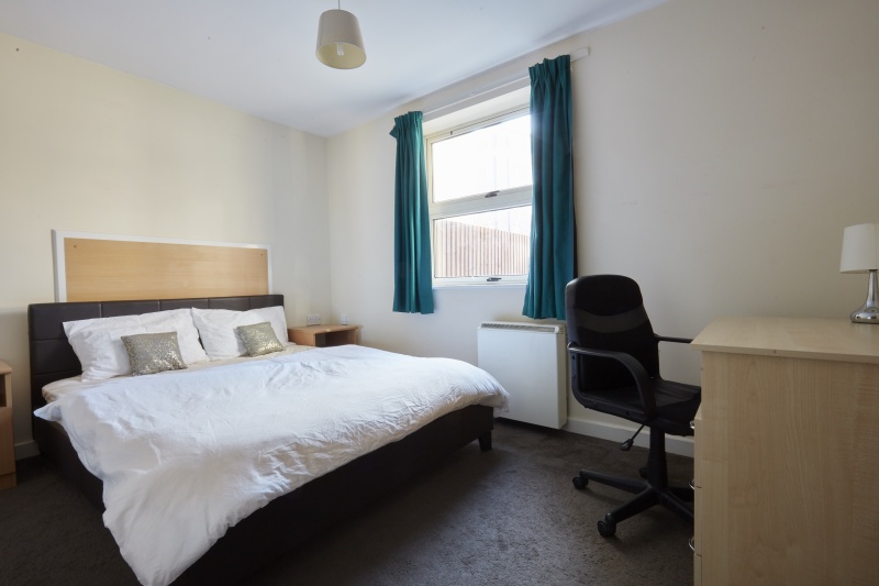 double comfortable bed with a study desk and window at Bedford Street South, Liverpool