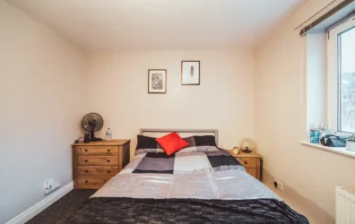 Cozy bedroom with a large bed, wooden nightstands, and framed wall art.
