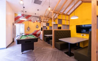 Social space including a TV lounge, pool table, and seating areas for student interaction
