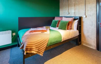 Cozy bedroom at Béton House student accommodation in Sheffield with a study desk and wardrobe