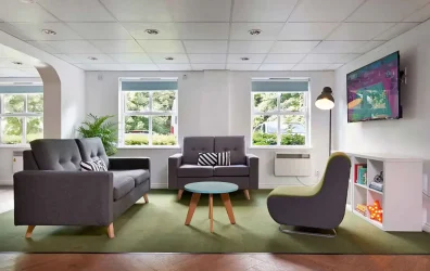 Social area at Snow Island student accommodation Huddersfield with modern seating and a large TV
