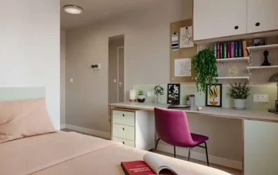 Cozy bedroom with a desk and chair at Station Court student accommodation, London