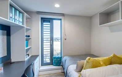 Private en-suite room with bed, desk, and storage at Riverside Quay