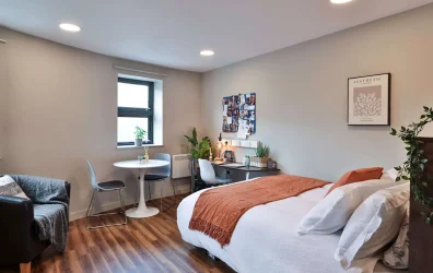 student bedroom with double bed, desk, and storage at Ladybarn House, Manchester